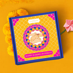 Gift box with 'Happy Raksha Bandhan' text on a yellow background with marigold flowers and plantable rakhi 